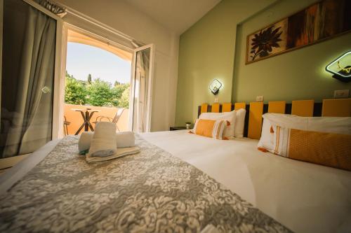 a bedroom with a large bed with a large window at Marina Studios in Sidari