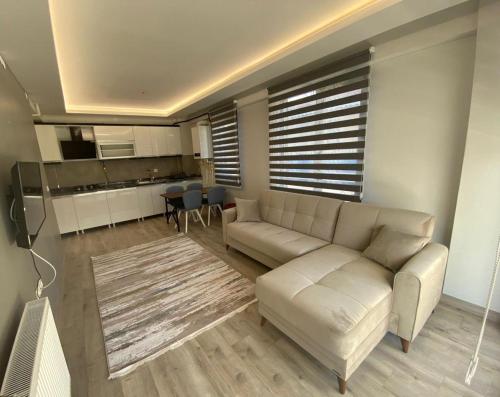 a living room with a white couch and a kitchen at lizbon suit in Talas