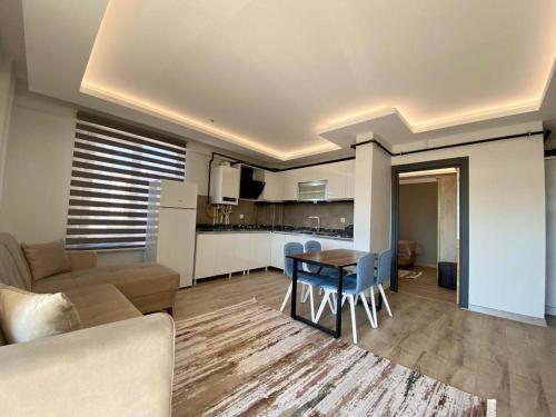 a kitchen and a living room with a table and a couch at lizbon suit in Talas