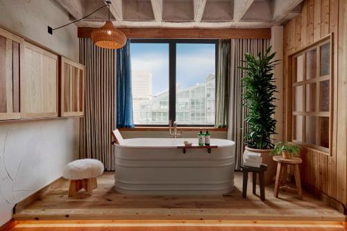 a bathroom with a large tub and a window at Treehouse Hotel Manchester in Manchester