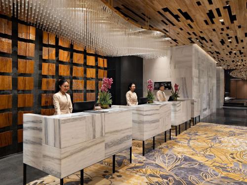 a group of people standing at a reception desk at Mövenpick Hotel Jakarta City Centre in Jakarta