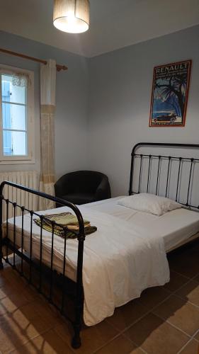 a bedroom with a bed with a chair and a window at Domaine de Beaudon Les Coucous in Augerville-la-Rivière