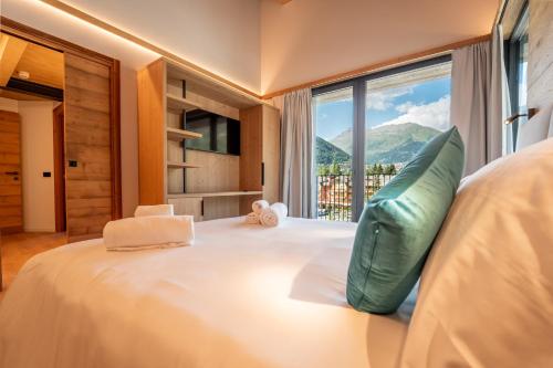 a bedroom with a large bed with a large window at Echo - Private Spa Apartments in Ponte di Legno