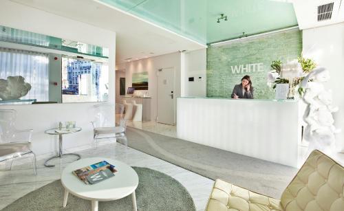 فندق وايت لشبونة في لشبونة: وجود امرأة جالسة على منضدة بيضاء في غرفة