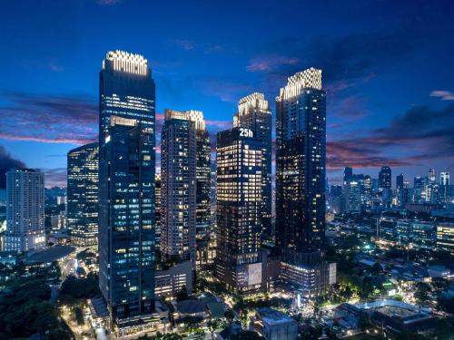a city skyline at night with tall buildings at 25hours Hotel Jakarta The Oddbird in Jakarta