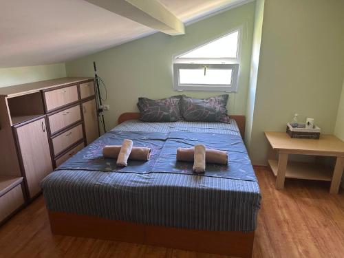a bedroom with a bed with two towels on it at Къща за гости Амбър in Burgas
