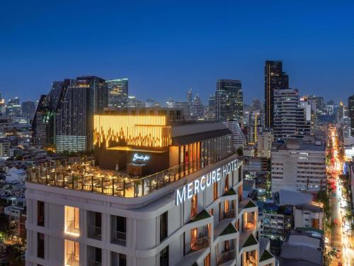 a view of the metropole hotel at night at Mercure Bangkok Surawong in Bangkok