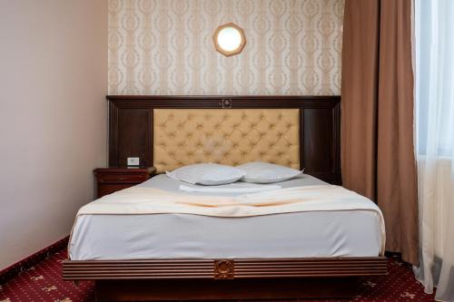 a bedroom with a large bed with a headboard at Pensiunea ORIENT in Brăila