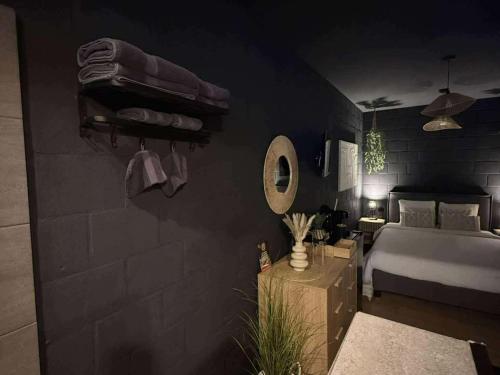 a black bedroom with a bed and a mirror at Au bât Tournai chambre Bohème in Tournai