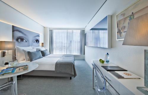ein Schlafzimmer mit einem Bett und einem großen Fenster in der Unterkunft Hotel White Lisboa in Lissabon