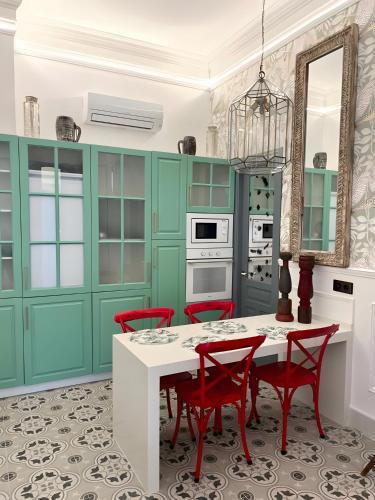 a kitchen with green cabinets and a table with red chairs at Apartamento El Mar Azul 5 in Torremolinos