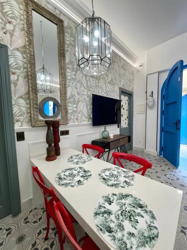 a dining room with a white table and red chairs at Apartamento El Mar Azul 5 in Torremolinos