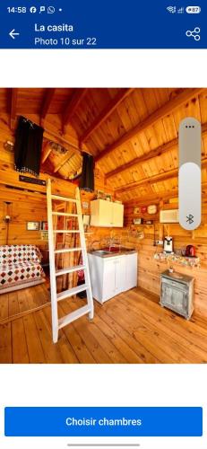a room with a wooden ceiling with a ladder in it at La casita in Villefranque