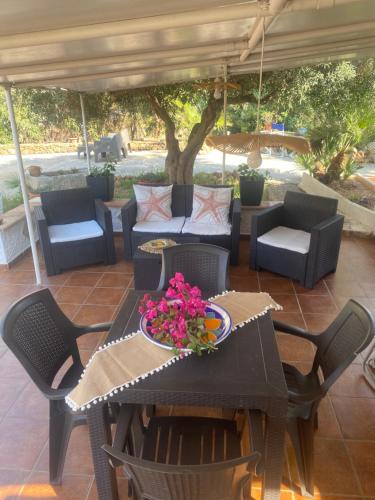 a table and chairs with flowers on a patio at Villamare in Custonaci