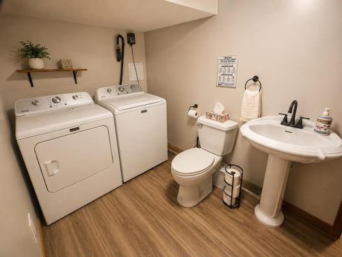 a bathroom with a washing machine and a sink at Chalet avec spa et lac privé in Saint Come