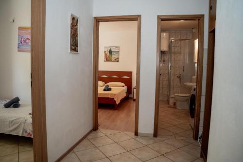 a hallway to a bedroom with a bed and a bathroom at Villa Best Relax in Okrug Donji
