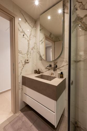 a bathroom with a sink and a mirror at ΛΑΚΩΝΙΖΕΙΝ Luxury Suites in Sparta
