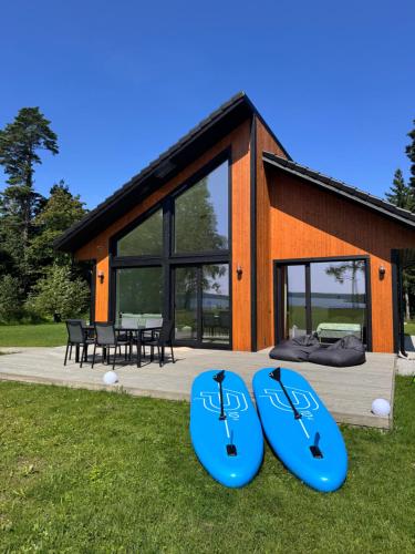 two blue surfboards sitting on the grass in front of a house at Järvemetsa Stay in Dejevo