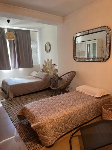 a bedroom with two beds and a mirror at Mar de rosas in Carcavelos