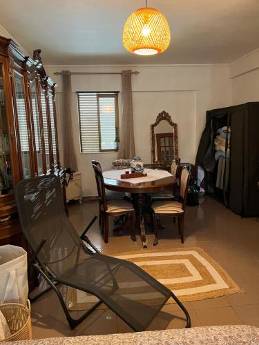 a dining room with a table and chairs and a chandelier at Mar de rosas in Carcavelos