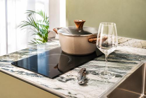a counter with a pot and a glass of wine at Residenza Ximenes in Palermo
