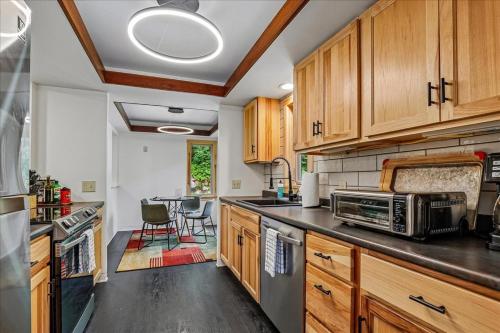 a kitchen with wooden cabinets and a table with chairs at The Mercer House in Stowe