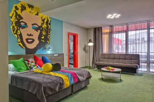 ウージュホロドにあるEmigrand Art Hotelのベッドルーム1室(壁に絵画が描かれたベッド1台付)