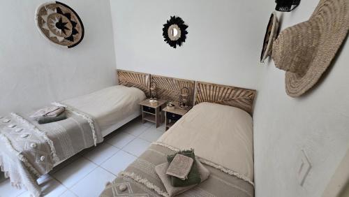 a bedroom with two beds and a clock on the wall at Favone Mini Villa Playa del Oro in Favone