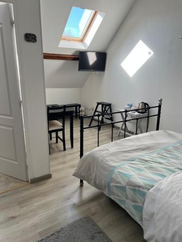 a bedroom with a bed and a table and a window at Chez Karen in Montlay-en-Auxois