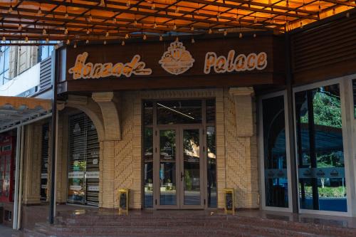 a restaurant with a sign on the front of a building at Hanzade Palace in Samarkand
