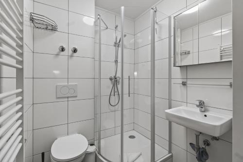 a bathroom with a shower and a toilet and a sink at AJO Apartments - Vetmed - Self-Check-in in Vienna