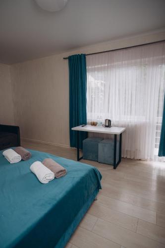 a room with two beds and a table and a window at NACHIKU Bukovel Resort & SPA in Palyanytsya