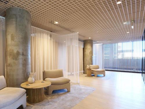 a lobby with a couch and a chair and a table at ibis Styles Melbourne Airport in Melbourne