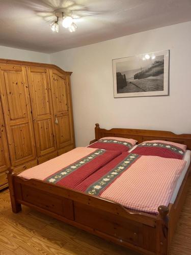a bedroom with a wooden bed and wooden cabinets at Auf der Woad in Tittmoning