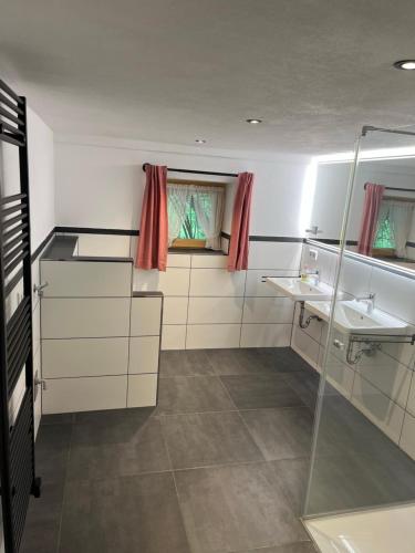 a bathroom with two sinks and a shower at Auf der Woad in Tittmoning