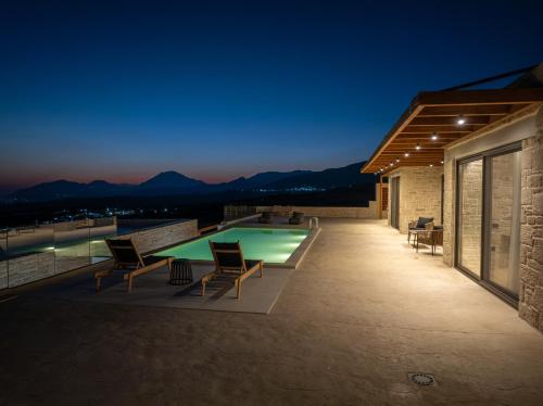 a pool on the roof of a house at night at Infinity View Luxury Villas in Galiá