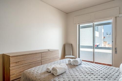 a bedroom with a bed with towels on it at HolidaysPT - Luanda - 2 Bedroom Apartment in Olhão