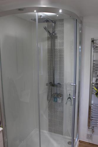 a shower with a glass door in a bathroom at Collis Annexe in Didcot