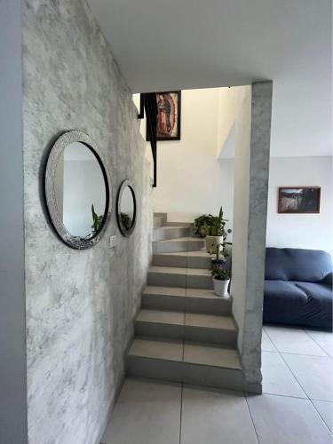 a hallway with a staircase with a mirror and a blue couch at Alojamiento el Toro in Gómez