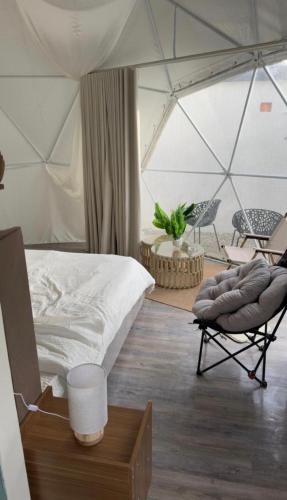 a bedroom with a tent with a bed and a chair at سكون in Al Baha
