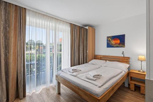 a bedroom with a bed and a large window at AJO Apartments - Vetmed - Self-Check-in in Vienna