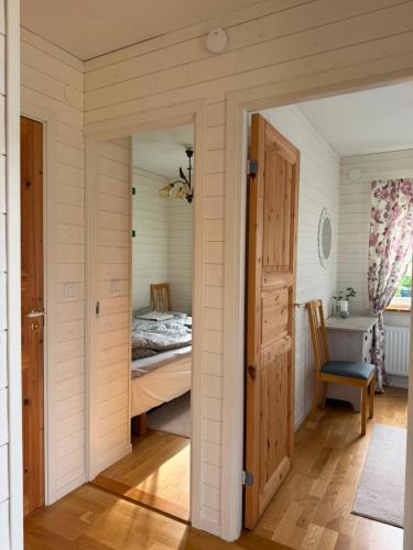 a room with a bedroom with a bed and a door at Charming cottage on Kvegero in Gnesta