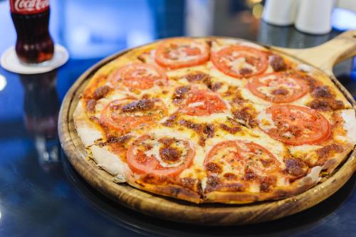 a pizza sitting on top of a wooden table at Hotel Intourist Palace Batumi in Batumi