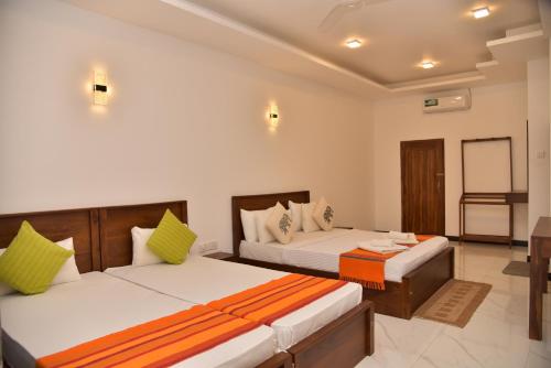 a hotel room with two beds and a table at Buddika Safari & Resort in Udawalawe