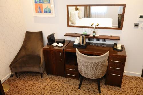 a desk with a mirror and a chair in a room at Mercure London Paddington Hotel in London