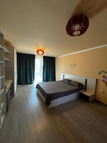 a bedroom with a bed and a large window at Vila La Cazemată Bucov in Satu Bucovei