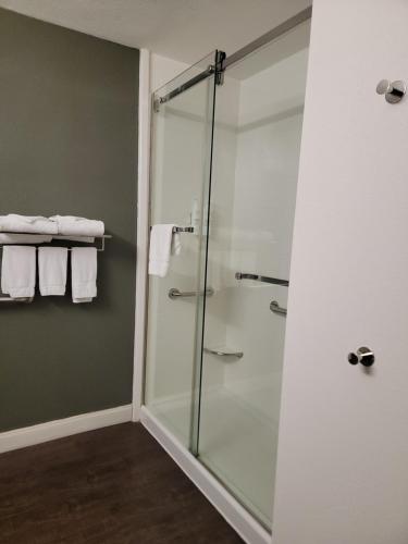 a glass shower stall in a bathroom with towels at Dyersburg Hotel in Dyersburg