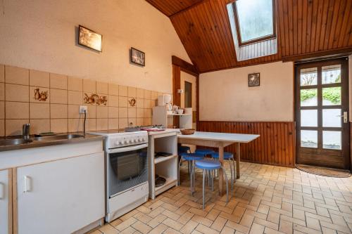 a kitchen with a table and a stove top oven at On The Rocks - Alpes Mancelles - Jardin in Sillé-le-Guillaume
