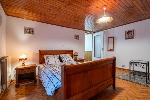 a bedroom with a bed and a wooden ceiling at On The Rocks - Alpes Mancelles - Jardin in Sillé-le-Guillaume