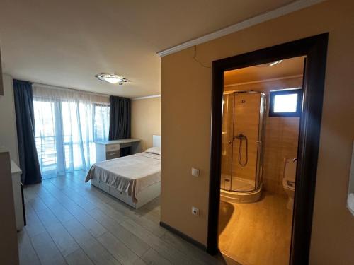 a bedroom with a bed and a shower in it at Vila La Cazemată Bucov in Satu Bucovei
